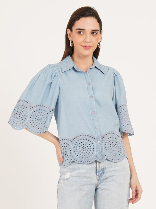 Woman wearing a light blue blouse with eyelet details with button closure  by 9 Impression